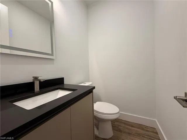 Modern vanity with an integrated rectangular sink, dark countertop, and contemporary faucet