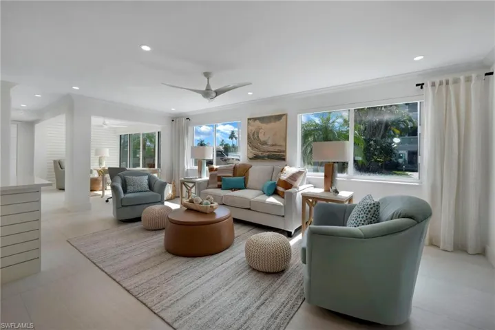Tiled living room with ornamental molding and ceiling fan
