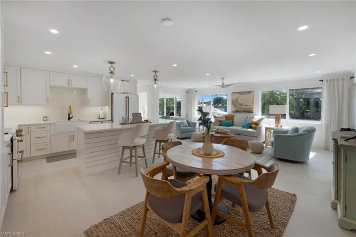 Tiled dining area featuring plenty of natural light, sink, and ceiling fan