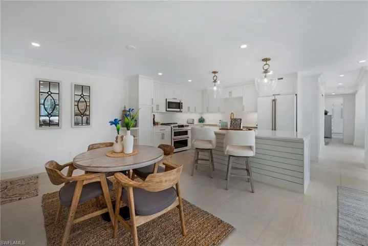 Tiled dining room featuring crown molding