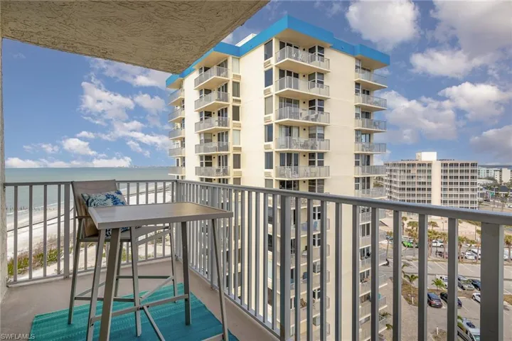 Balcony featuring view of water and beach