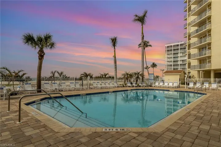 Pool at dusk with a patio and a community pool