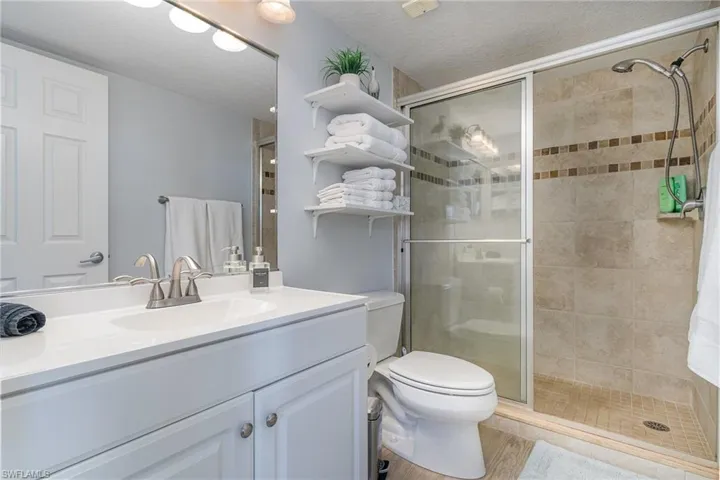 Full bathroom with vanity, a textured ceiling, and a shower stall
