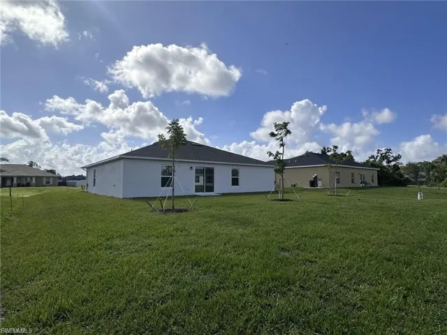 Back of house featuring a yard and stucco siding