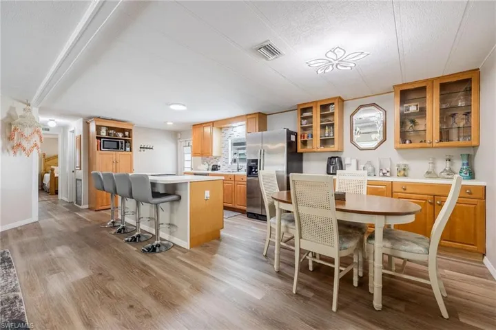 Kitchen with a breakfast bar, a center island, light wood-style floors, visible vents, and stainless steel appliances