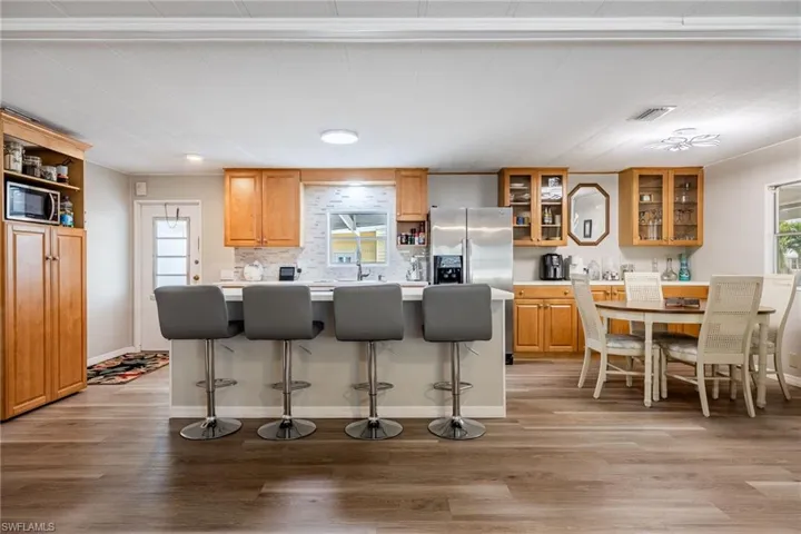 Kitchen featuring a healthy amount of sunlight, light wood-style flooring, a breakfast bar area, and appliances with stainless steel finishes