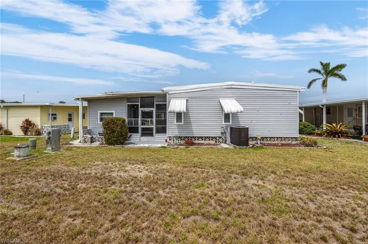 Back of house featuring a yard, a sunroom, and central air condition unit