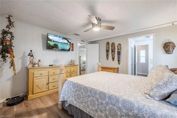 Bedroom with light wood-type flooring, a ceiling fan, and visible vents