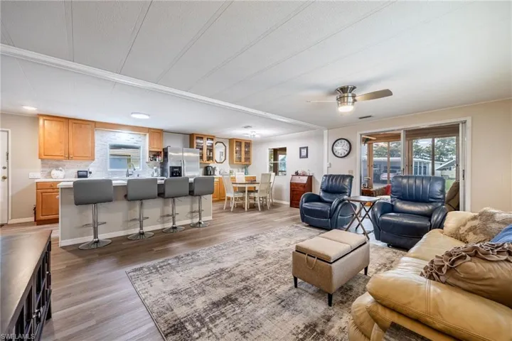 Living room featuring light wood finished floors, baseboards, and a ceiling fan