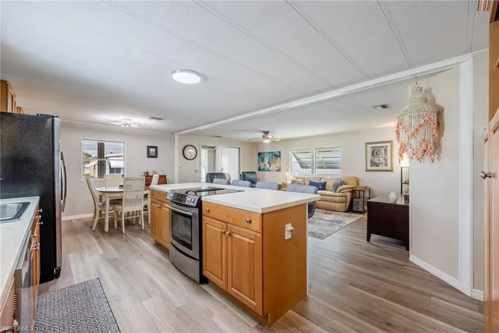 Kitchen with light wood-style floors, light countertops, a center island, and stainless steel appliances