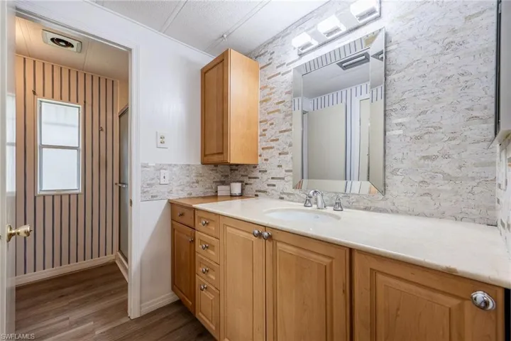 Bathroom featuring wood finished floors, vanity, and baseboards