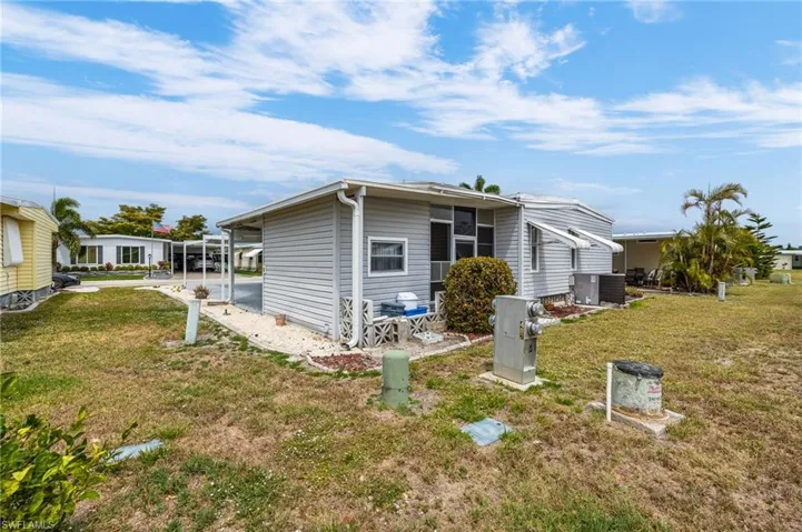 View of side of property featuring a yard and central AC unit