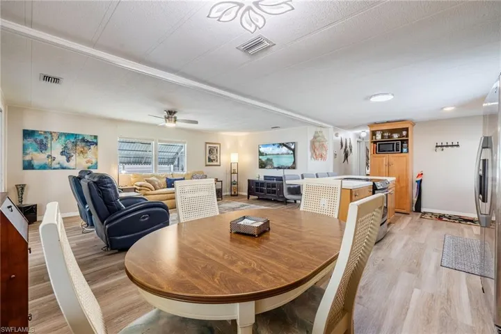 Dining room with light wood-style floors, visible vents, baseboards, and a ceiling fan