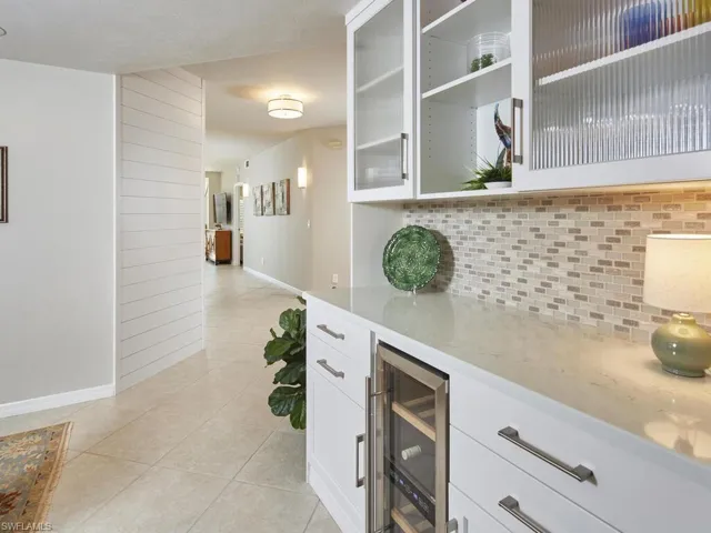 White custom cabinetry and decorative backsplash.