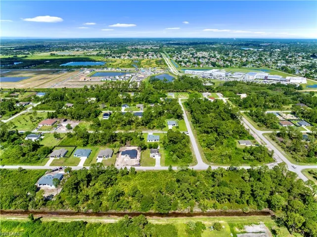 Aerial view of property's location with a nearby body of water and a tree filled landscape