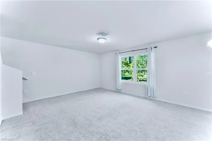 Spare room featuring carpet floors and baseboards