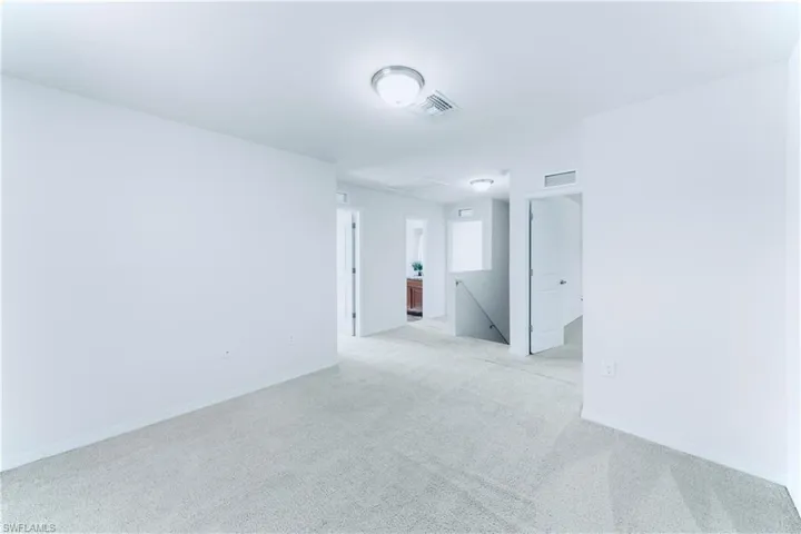 Unfurnished room featuring light colored carpet and baseboards