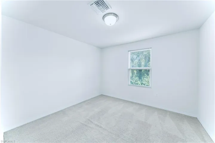 Empty room featuring carpet flooring and baseboards