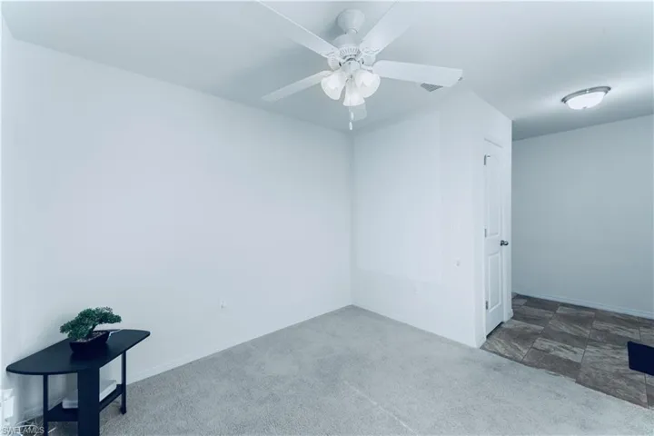 Empty room featuring carpet and ceiling fan