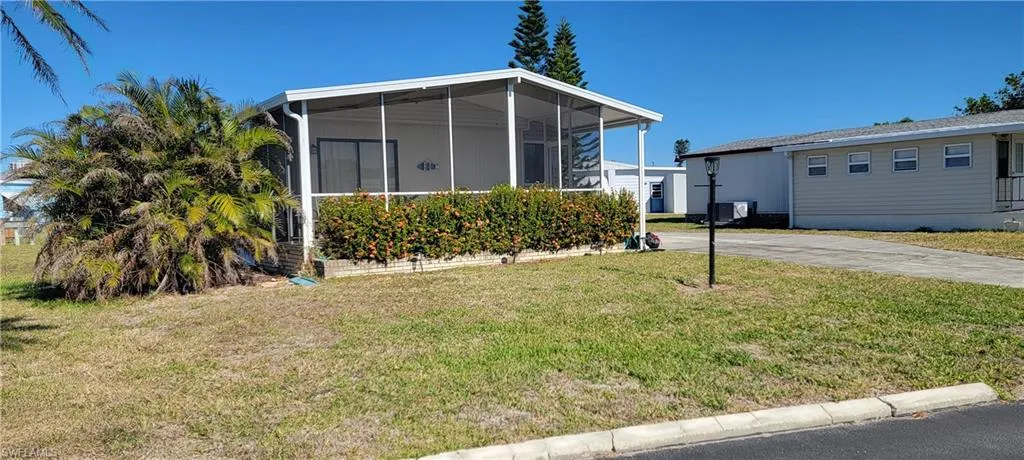 View of front of property with a front lawn and a sunroom