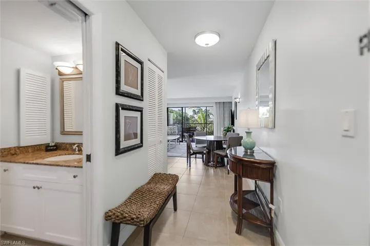 Corridor featuring light tile patterned floors and a sink