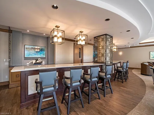 Bar with pendant lighting and light stone countertops