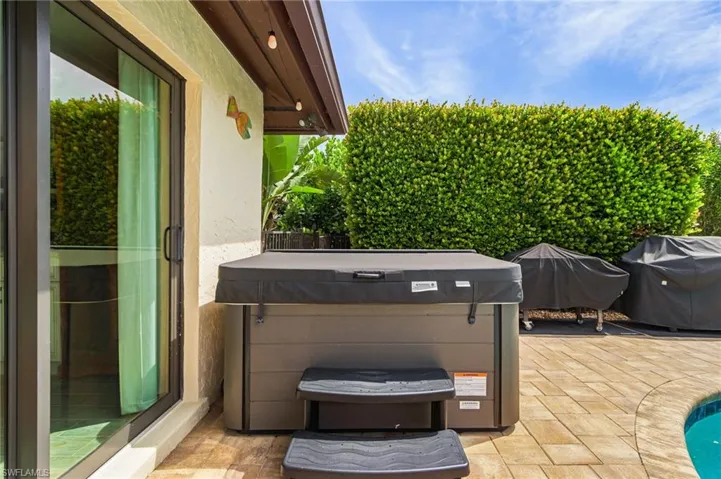 View of patio with a grill and a hot tub