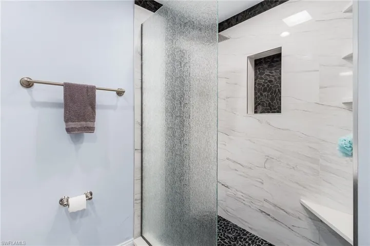 Bathroom featuring a marble finish shower