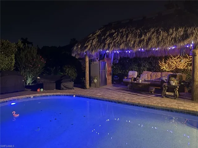 Pool at twilight with a patio and an outdoor hangout area