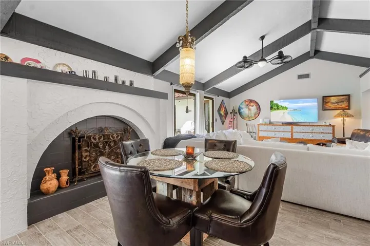 Dining area featuring wood tiled floors and a fireplace with raised hearth