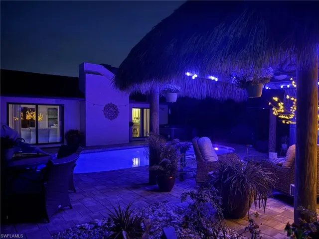 Patio at night featuring a hot tub and a patio