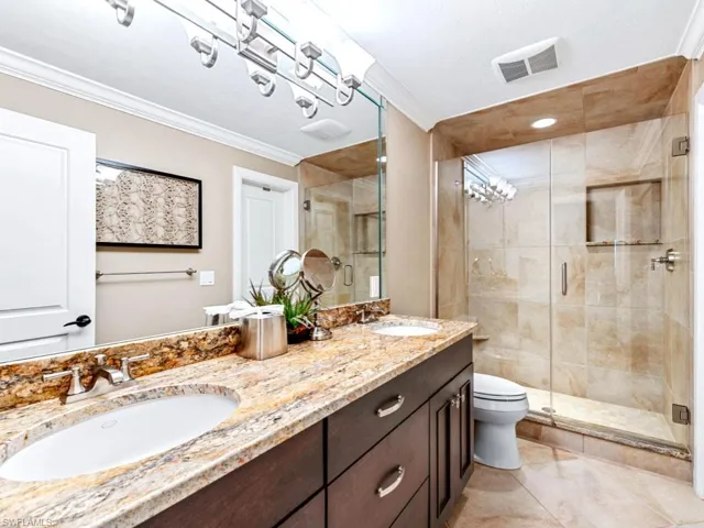 Full bathroom featuring a sink, visible vents, ornamental molding, and a stall shower