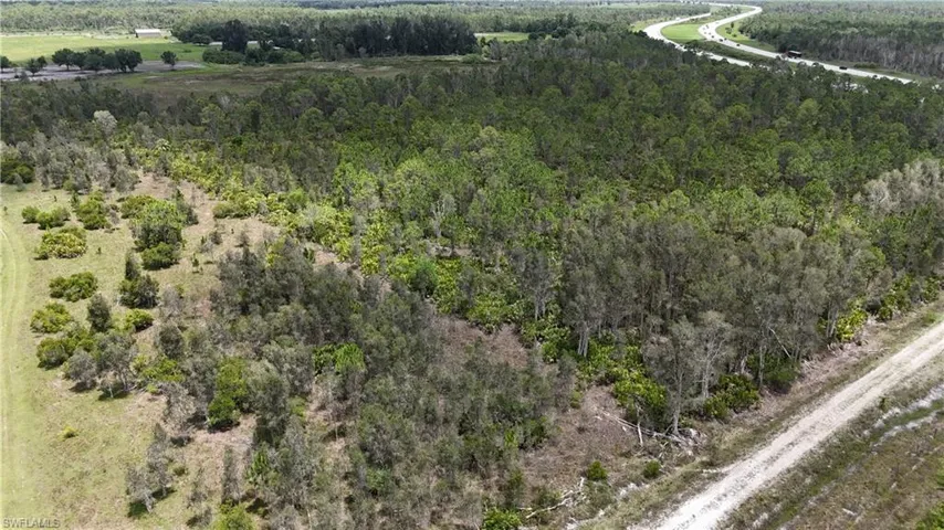 Aerial view of property and surrounding area featuring a heavily wooded area