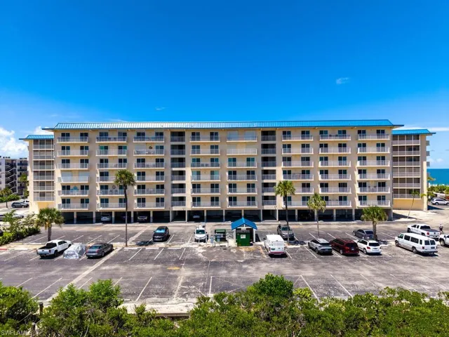 View of apartment building / complex with uncovered parking
