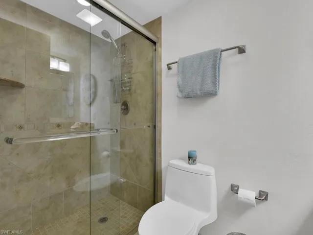 Bathroom with a shower stall and toilet