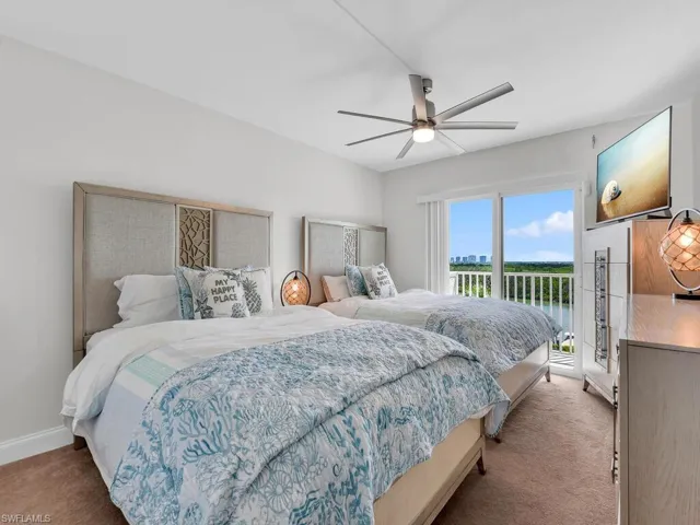 Carpeted bedroom with access to exterior and a ceiling fan