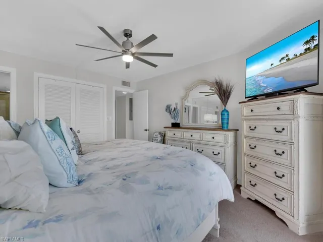 Bedroom featuring light carpet, ceiling fan, and a closet