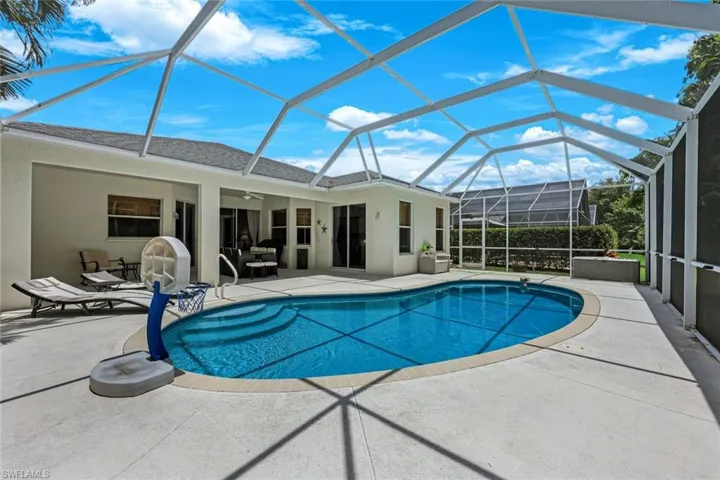 Swimming pool featuring a patio area, a ceiling fan, and glass enclosure