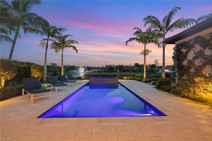 Pool at dusk featuring a patio