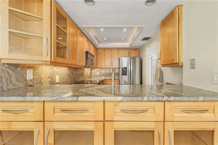 The updated kitchen provides ample cabinetry, granite countertops and stainless. steel appliances.