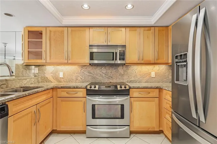 The kitchen boasts beautiful cabinetry, stainless steel appliances and gorgeous granite countertops and backsplash.