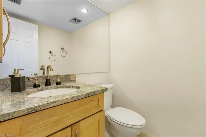 The main living area's powder room has a raised vanity, granite countetop and new toilet.