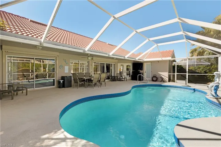 Outdoor pool featuring screened enclosure/lanai,  a patio area, and ceiling fan