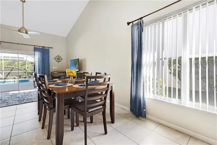 Dining space featuring light tile patterned floors and high vaulted ceiling