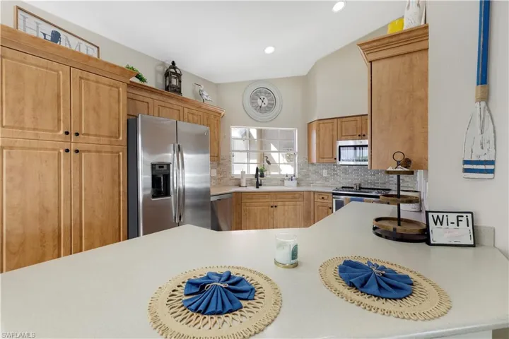 Kitchen featuring appliances with stainless steel finishes, light countertops, decorative backsplash, a peninsula, and recessed lighting