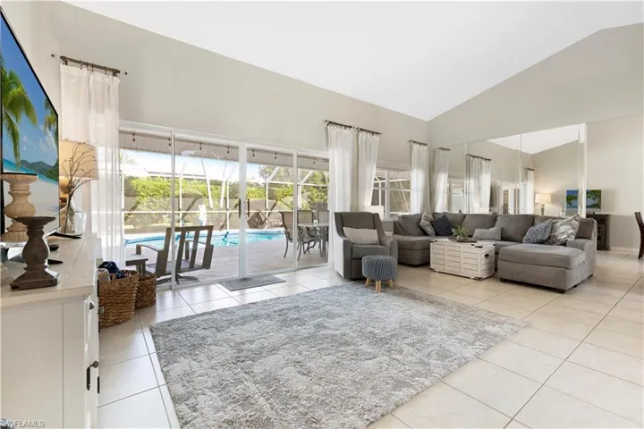 Living area with high vaulted ceiling and light tile patterned floors