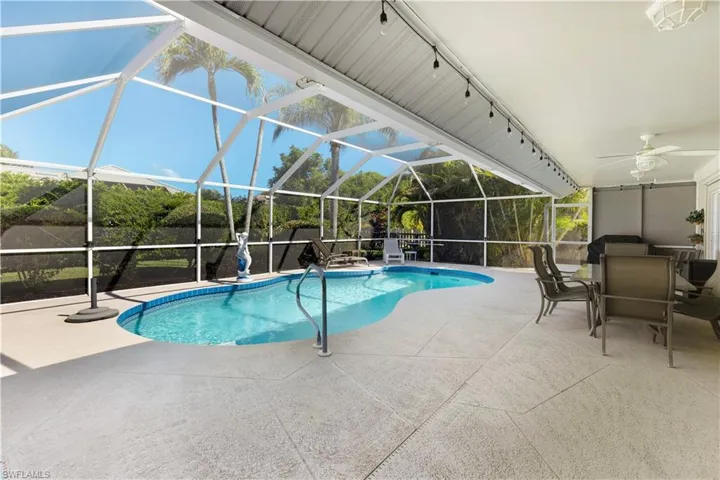 Swimming pool featuring screened lanai/enclosure, a patio, and a ceiling fan