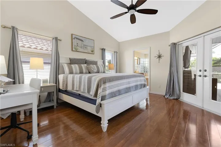 Master Bedroom with access to exterior, dark wood-style floors, french doors, a ceiling fan, and high vaulted ceiling