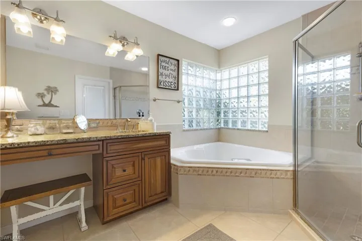 Master Bathroom featuring a garden tub, vanity, a shower stall, and light tile patterned floors