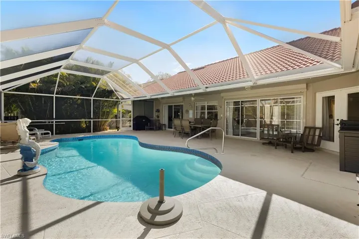 Outdoor pool featuring a lanai, a patio area, and a ceiling fan